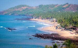 Blof Anjuna beach and green mountains on the shoresue water