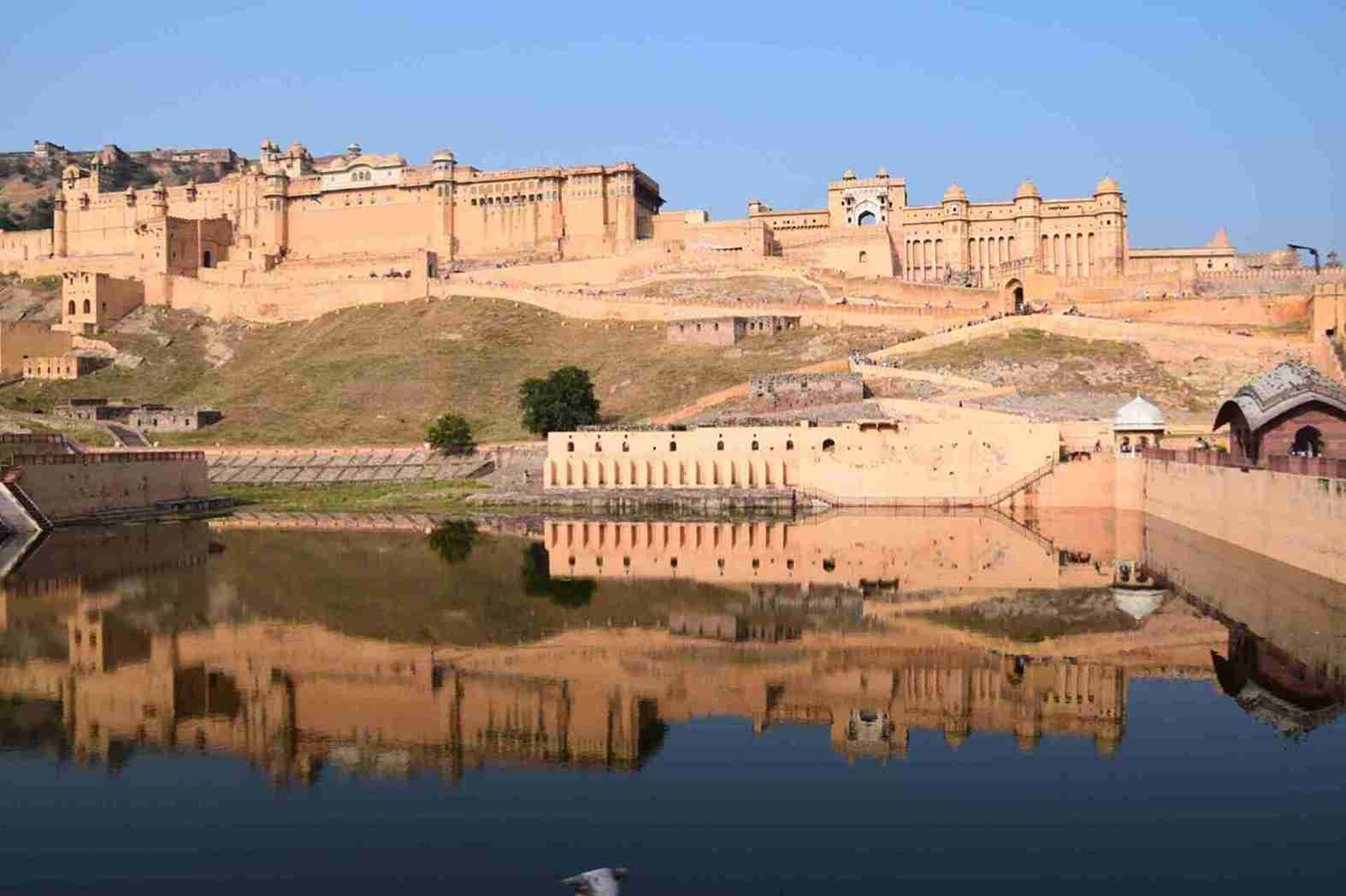 Amber fort jaipur has big walls and a lake nearby it