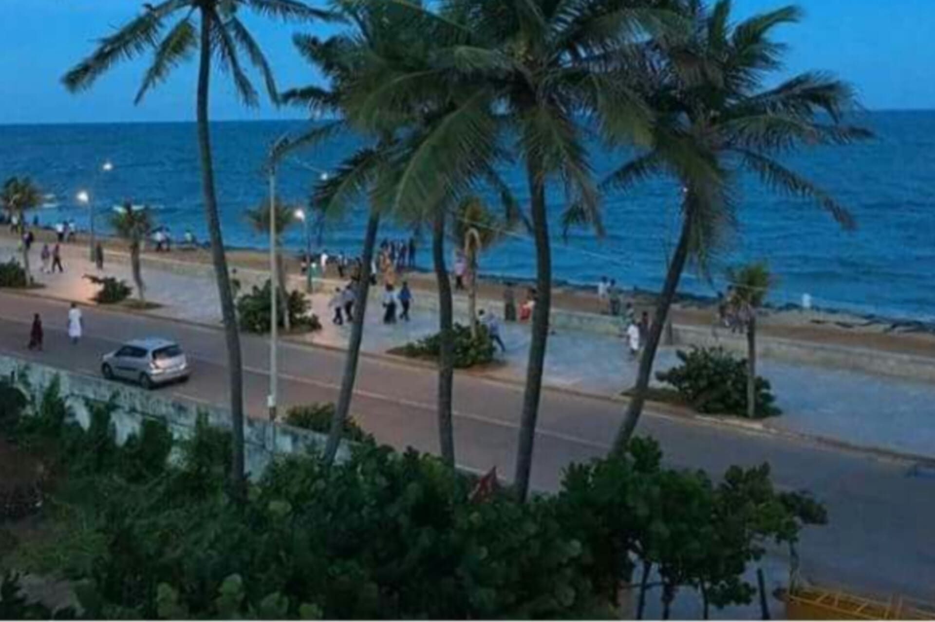 Palm trees are present and some people are visible