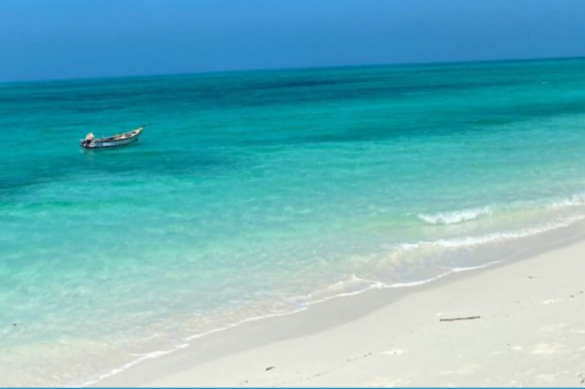 transparent sea water and has a boat on it