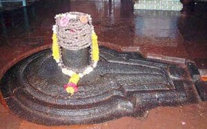 This is a black colour jyotirlinga of lord shiva and yellow colour garland around shivling