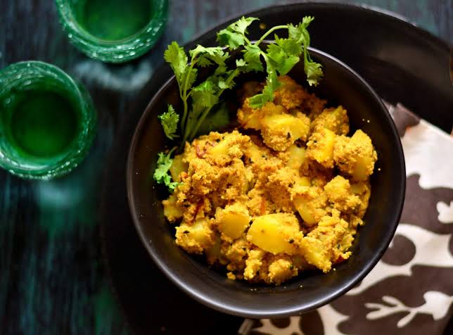 Aloo posto is taken in the black bowl and yellow in color वेस्ट बंगाल के लोकप्रिय व्यंजन