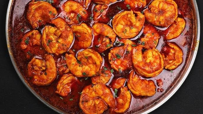 Chingri malai curry is looks reddish with curry in the bowl in वेस्ट बंगाल के लोकप्रिय व्यंजन
